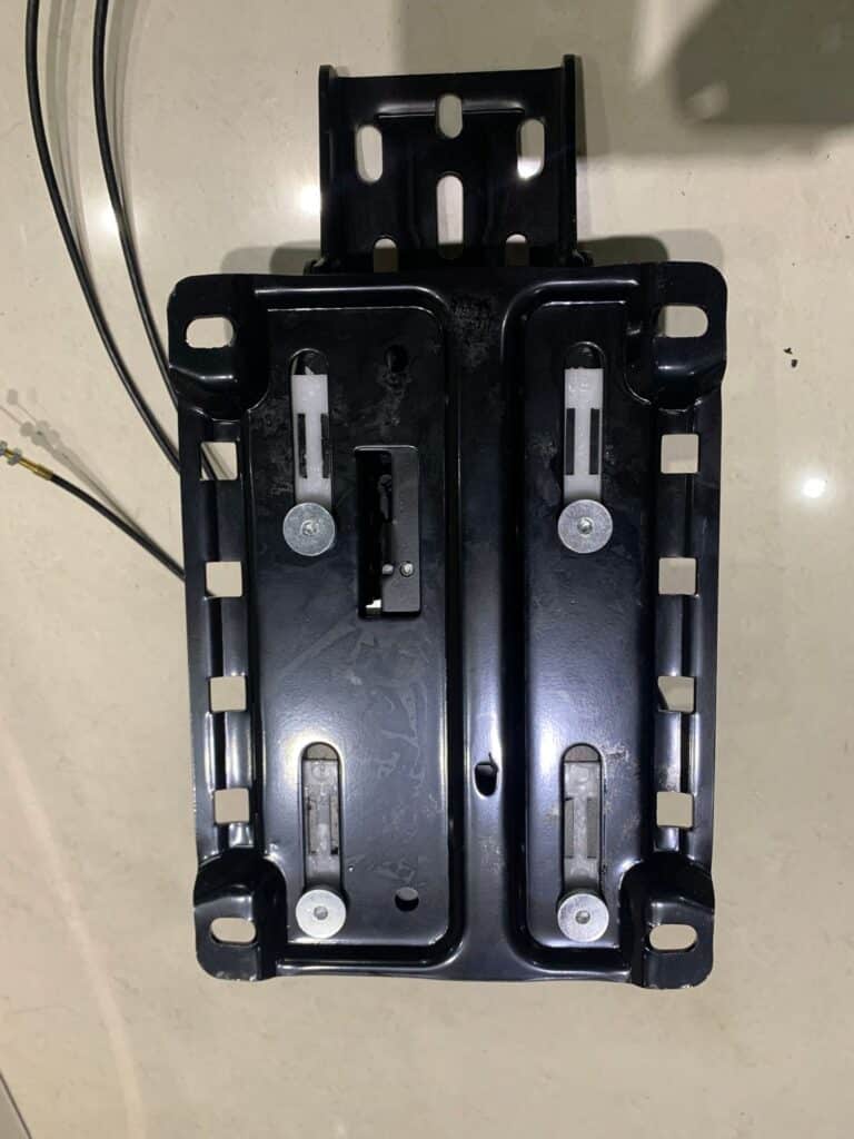 Bottom view of a wire-controlled office chair mechanism highlighting sliding seat rails and secure fastening bolts.